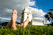 Feet of tourist relaxing in front of Belem Tower, Belem, Portugal