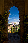 View of town through arched window of Alcazaba, Malaga, Andalucia, Spain