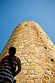 Girl looking at castle tower in medieval village, Pals, Costa Brava, Catalunya, Spain