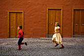 Children (5-7) running in street at International Carnival of Puerto de la Crux in Gran Coso Apoteosis, Tenerife, Canary Islands, Spain