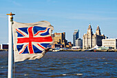 Three Graces in Liverpool skyline with Union Jack flag, Liverpool, England