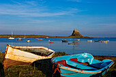 View across water and boats to Lindisfarne Castle on Holy Island, Northumberland, England, United Kingdom.