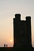 Silhouette of romantic couple and Broadway Tower, dusk, Cotswolds, Worcestershire, England, UK