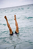 Legs sticking out of sea, Jupiter, Florida, USA