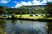 Colourful tents in a valley campsite, next to a river, surrounded by hillsides, Llyn Gwynant Campsite, Nantgwynant, Snowdonia National Park, North Wales