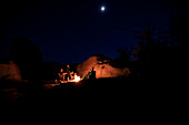 Drei Menschen sitzem gemeinsam am Lagerfeuer, Joshua Tree National Park, Kalifornien, USA