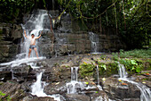 A man showers under a waterfall at Cascada de Latas, Amazone, Ecuador, South America