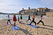 People doing yoga on the beach Plage de la Gravette, old town of Antibes, Cote d'Azur, South France, Europe