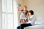 Young couple at a pillow-fight in a bedroom, Hamburg, Germany