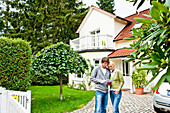 Young couple is looking at documents in front of a house, Hamburg, Germany