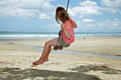 Young Girl on Rope Swing under Pohutukawa Tree, Waihi Beach, Coromandel, North Island, New Zealand