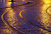 city, cobble, cobblestones, curve, Czech, dusk, light, headlights, metal, pattern, paving, perspective, Prague, rain, reflection, republic, road, roadway, stone, street, surface, track, tram, tramway, wet. city, cobble, cobblestones, curve, Czech, dusk, l