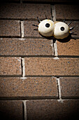 Cartoon Eyes Stuck to Brick Wall