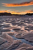Wharariki beach at low tide, sunrise lights up pools in sand, near Archway Islands, Golden Bay
