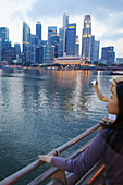 Women taking pictures in front of Singapore Skyline, Singapore, Asia