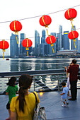 Passanten und Lampions vor der Skyline von Singapur, Singapur, Asien