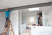 Two women renovating an appartment, painting a beam, Leipzig, Saxony, Germany