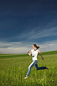 Girl running barefoot through a meadow, Upper Bavaria, Bavaria, Germany