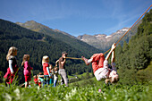 Mädchen hangelt an einem Seil, Hotel Feuerstein, Gossensaß, Brenner, Südtirol, Trentino-Südtirol, Italien