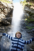 Boy in front of a waterfall in the South Tyrolean mountains, Pflersch, Gossensass, South Tyrol, Italy