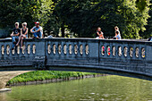 Menschen auf einer Fussgängerbrücke über dem Nymphenburger Kanal, Gern, München, Oberbayern, Bayern, Deutschland, Europa