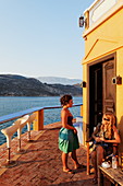 People outside of Faros-Coupa bar in the evening sun, Kastelorizo Megiste, Dodecanese Islands, Greece, Europe