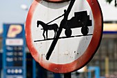 Road sign in Babadag, forbidden for horse carts and modern petrol station, old and new times, Romania