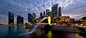 Singapore skyline and Merlion statue in evening twilight, viewed from Merlion Park, Singapore
