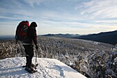 Appalachian Trail - A winter hiker stands on the summit of Mount Moriah during the winter months in the White Mountains, New Hampshire USA