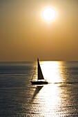 A sailboat navigating in the water with sunlight