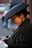 A young female jinrikisha driver waits for customers along Kaminarimon Avenue in Asakusa, located in the old shitamachi downtown district of Tokyo, Japan.