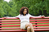 Businesswoman sitting in a bench in a Park in the pause from work
