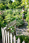 Frau bei der Gartenarbeit, Haus Strauss, Bauernkate in Klein Thurow, Roggendorf, Mecklenburg-Vorpommern, Deutschland