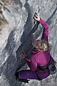 Junge Frau klettert an einer Felswand, Pinswang, Tirol, Österreich, Europa