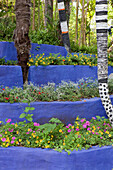 Painted tree trunks and terrace beds at Andre Hellers' Garden, Giardino Botanico, Gardone Riviera, Lake Garda, Lombardy, Italy, Europe