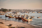 Zahlreiche bunte Fischerboote am Strand von Mui Ne, Vietnam, Südchinesisches Meer