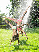 Girls playing under a water_jet. Girls playing under a water_jet