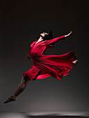 Frau in rotem Kleid tanzt im Scheinwerferlicht