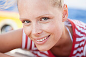 woman smiling at viewer sitting on deck