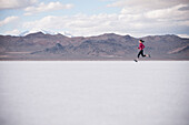 Woman running in desert landscape. Bonneville Salt Flats State Park