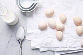 Eggs, milk and spoon on table. QSCOpenerStarter