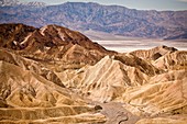 Tourists at the badlands at Zabriskie Point looking toward Golden Canyon in Death Valley National Park, Nevada, USA  Zabriskie point was once the home of twenty-mule team borax mines