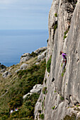 Young women climbing in a steep wall, hiking and climbing on Mallorca, climbing area La Creveta, Cap Formentor, Mediterranean Sea, La Creveta, Cap de Formentor, Serra de Tramuntana, Unesco World Cultural Heritage, Mallorca, Spain