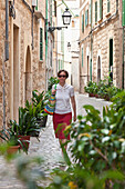 Old town of Soller,  woman walking in an alley, Tramuntana, Soller, Mallorca, Spain