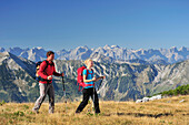 Young woman and young man hiking, Karwendel range in background, Unnutz, Brandenberg Alps, Tyrol, Austria