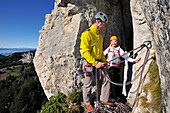 Junger Mann sichert junge Frau am Felsen, Kampenwand, Chiemgauer Alpen, Chiemgau, Oberbayern, Bayern, Deutschland