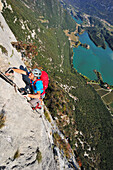 Junger Mann klettert am Klettersteig Rino Pisetta, Lago die Toblino, Sarche, Calavino, Trentino, Trentino-Südtirol, Italien