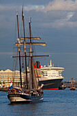 Segelschiff vor dem Kreuzfahrtschiff Queen Mary 2 am Anleger im Hamburg Cruise Center Hafen City, Hamburg, Deutschland, Europa