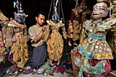 Myanmar (Burma), Mandalay State, Mandalay, craft shop, Aung Zaw repares a puppet representing a Nat, a Burmese spirit