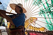 Thailand,Chiang Mai,Borsang Umbrella Village,Workers Carrying Giant Umbrellas